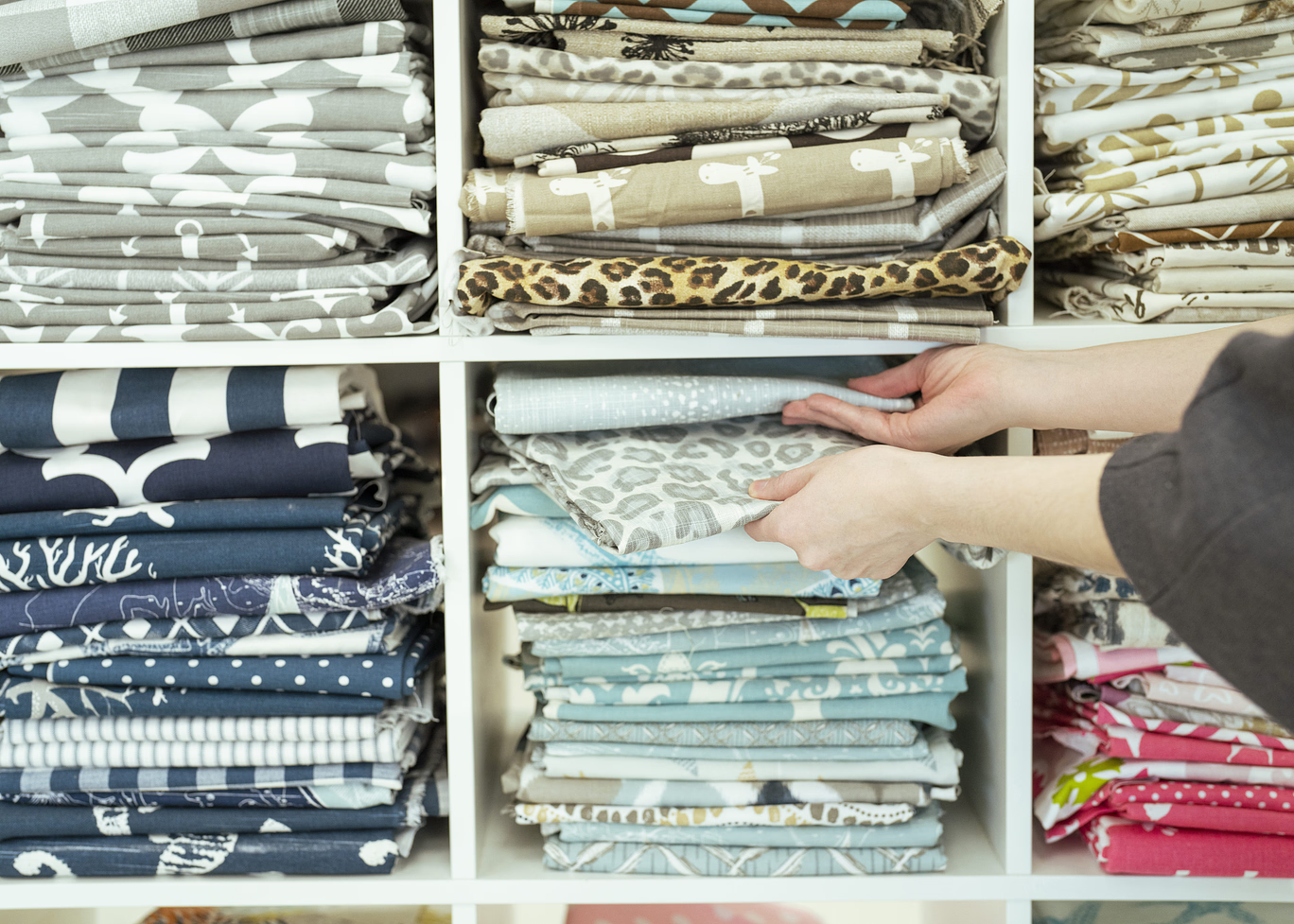 Shelves of folded fabric samples for custom pet beds