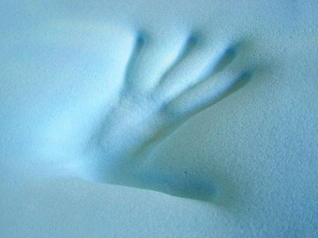 Handprint pressed into memory foam showing its responsive support