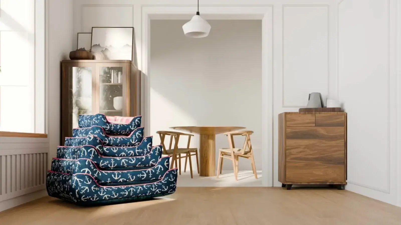 A stack of navy anchor-print Cuddle Beds in a bright dining room
